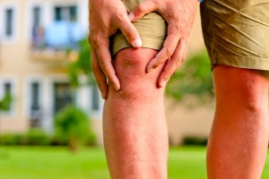 man holding hands sore knee